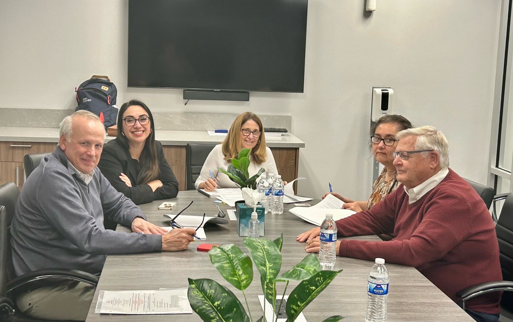 Representatives of the Desert Healthcare District & Foundation and Tenet Health sit at a table with a notary public. Documents and pens are on the table. Staff Photo