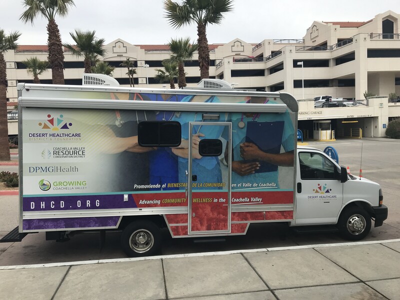 The District & Foundation's colorful mobile medical van is parked on the street.